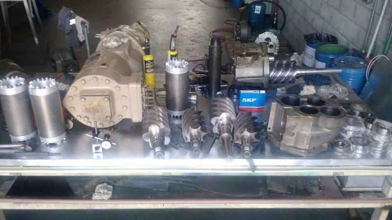 Componentes de compressor parafuso na bancada durante overhaul